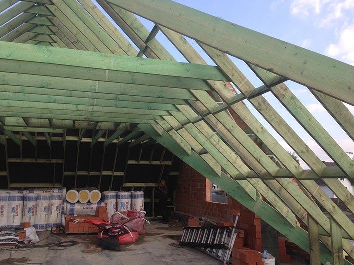 Houten dakstructuur met isolatie in een woning in opbouw